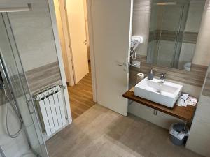 y baño con lavabo y ducha. en Hotel Il Duca barbablu, en Sabbioneta