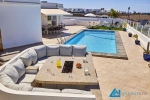 eine Terrasse mit einem Sofa und einem Pool in der Unterkunft Casa Nostra - LH195 By Villas Now Ltd in Playa Blanca