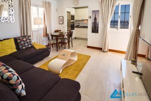 ein Wohnzimmer mit einem Sofa und einem Tisch in der Unterkunft Casa Nostra - LH195 By Villas Now Ltd in Playa Blanca