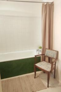a bathroom with a chair and a bath tub at T3 avec sa terrasse au cœur du village médiéval in Sauzet