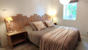 a bedroom with a bed with a wooden headboard at T3 avec sa terrasse au cœur du village médiéval in Sauzet +2 photos