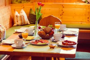 un tavolo con piatti di cibo e bicchieri di succo d'arancia di Haberjockelshof a Titisee-Neustadt