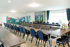 una gran sala de conferencias con una mesa larga y sillas en โรงเเรมวังสะพุงอินวิว, en Loei