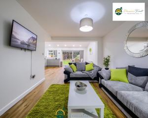 a living room with a couch and a table at LOW rate SPECIAL DEAL for a 3 Bedroom house with 2 Baths- near Coventry Community Centre and War Memorial Park with Parking and FREE unlimited Wi-fi - ARC in Coventry