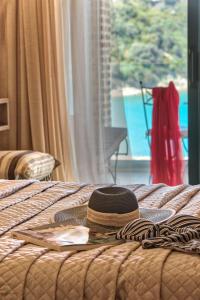 a hat sitting on top of a bed with a window at Porto Roma Seaside Studios in Vasilikos