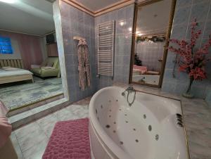 duża łazienka z wanną i sypialnia w obiekcie Motel DRABEK w Tarnowskich Górach