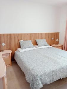 a bedroom with a large bed and two night stands at Granada playa! in Maspalomas