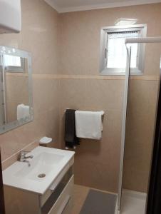 een badkamer met een wastafel, een spiegel en een raam bij Granada playa! in Maspalomas