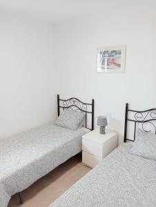 een slaapkamer met 2 bedden en een nachtkastje bij Granada playa! in Maspalomas