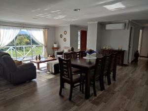 uma sala de jantar e sala de estar com mesa e cadeiras em Casa de campo em Curacautín