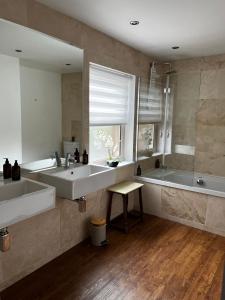 a large bathroom with two sinks and a tub at Carlton House - Spacious 4 Bed Victorian townhouse in Harrogate +40 photos