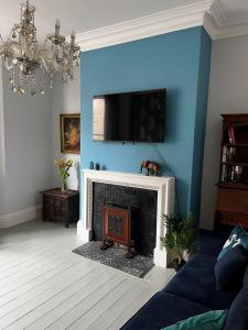 a living room with a fireplace with a flat screen tv at Carlton House - Spacious 4 Bed Victorian townhouse in Harrogate