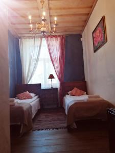 1 Schlafzimmer mit 2 Betten und einem Fenster in der Unterkunft Pilsberģu krogs in Jūrkalne