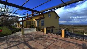 una casa amarilla con una valla delante en NATURA Sea View, en Izola