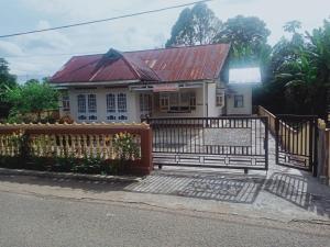 una piccola casa con cancello e recinzione di HOMESTAY PARAK KAYU a Baso