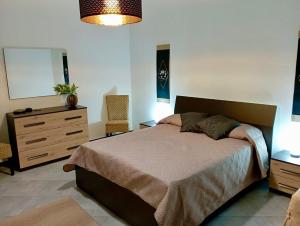 1 dormitorio con cama, tocador y espejo en A CASA DI GIANNA, en Napola