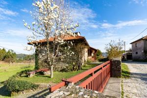 a building with a tree next to a fence at Casa do Castelo em Arnóia in Celorico de Basto