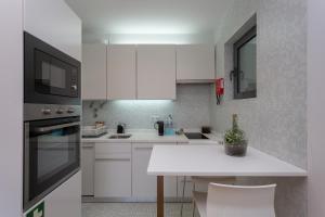 a kitchen with white cabinets and a white counter top at BeGuest Benfica Modern Flat in Lisbon