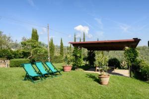 zwei blaue Stühle auf dem Rasen in einem Hof in der Unterkunft La Tuia Vacanze apt for 4PP and apt for 2PP in Montevarchi