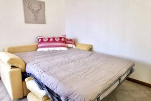 Una cama en una habitación con una almohada roja. en CASA APRICA 6 by Design Studio, en Aprica