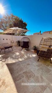 eine Terrasse mit 2 Stühlen und einem Sonnenschirm in der Unterkunft Honey Spa in Vitrolles