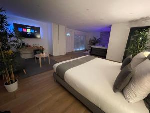 een slaapkamer met een groot bed en een kamer met planten bij Honey Spa in Vitrolles