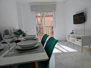 ein Esszimmer mit einem Tisch und grünen Stühlen in der Unterkunft Garu Apartamentos in Fuengirola