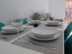 a table with plates and wine glasses on it at Garu Apartamentos in Fuengirola