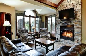 a living room with a couch and a fireplace at Chalets Alpins - 16 Chemin des Skieurs in Stoneham