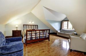 a attic room with a bed and a couch at Chalets Alpins - 16 Chemin des Skieurs in Stoneham +26 photos