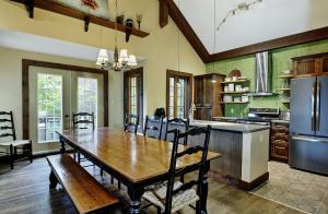a kitchen with a wooden table and a dining room at Chalets Alpins - 16 Chemin des Skieurs in Stoneham
