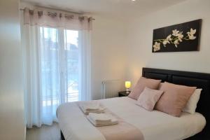 a bedroom with a large white bed with a window at Chez Lou et Dan 4P apartment with balcony elevator and secure parking in Honfleur