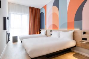 um quarto de hotel com duas camas e uma janela em B&B HOTEL Mechelen em Mechelen