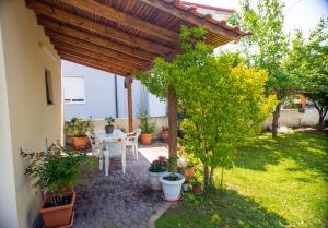 a patio with a table and chairs under a wooden pergola at Nikoleta House in Nea Vrasna +12 photos
