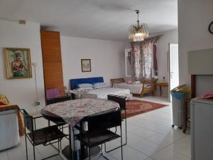 sala de estar con mesa y dormitorio en Villa Elisa lago e monti, en Carzago della Riviera