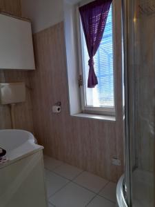 baño con ducha, lavabo y ventana en Villa Elisa lago e monti, en Carzago della Riviera