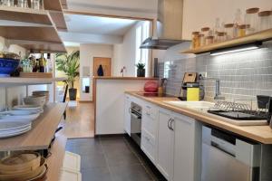 a large kitchen with white cabinets and a counter at Illuminated stall in Chartrons in Bordeaux