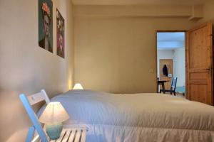 una camera da letto con un letto con una lampada e una sedia di Illuminated stall in Chartrons a Bordeaux