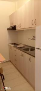 La cuisine blanche est équipée d'un évier et d'un réfrigérateur. dans l'établissement All Summer Villa Dafni, à Olympiakí Aktí