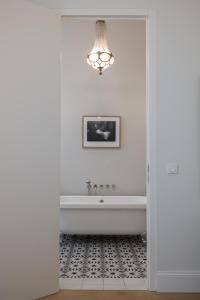 a bathroom with a bath tub and a chandelier at 2-Bedroom Apartment with Private Library in Vienna