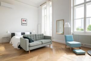 een witte slaapkamer met een bank en een bed bij 2-Bedroom Apartment with Private Library in Wenen