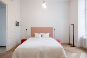 een slaapkamer met een groot wit bed met witte lakens bij 2-Bedroom Apartment with Private Library in Wenen