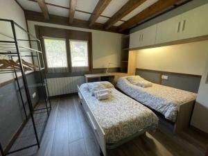 Gautegiz ArteagaにあるVen y disfruta en el corazón de Bizkaia-Urdaibaiのベッド2台と二段ベッド1組が備わる客室です。