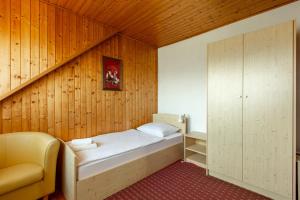 1 dormitorio con 1 cama en una pared de madera en Rooms Tereza en Bled