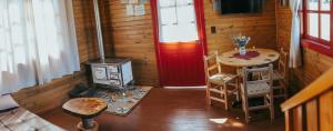 a room with a stove and a table and a red door at Hospedaria Locanda 65 - Garibaldi - Serra Gaúcha in Garibaldi