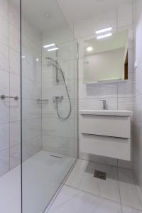 a white bathroom with a shower and a sink at Rooms Tereza in Bled