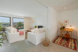 a living room with two white chairs and a table at CASA DO MIRADOURO 5 by Heart of Funchal in Funchal