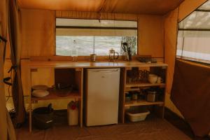 a kitchen with a sink and a refrigerator at Camping Onlycamp Le Sabot in Azay-le-Rideau