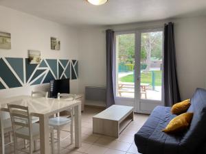 - un salon avec une table et un canapé dans l'établissement Les Villas des Pins, à Saint-Hilaire-de-Riez