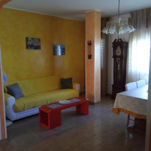a living room with a yellow couch and a table at Casa Limone in Petacciato